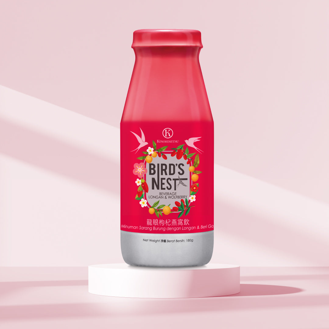 A bottle of KinohimitQDsu Bird's Nest beverage with Longan and Wolfberry, featuring a red label with floral and fruit decorations. The bottle is displayed on a white platform against a pink background. Kinohimitsu Bird's Nest with Longan and Wolfberry bottle displayed on a white pedestal against a soft pink background. The bottle has a red cap and a vibrant label featuring floral designs and images of longan and wolfberry, emphasizing the product's natural ingredients and health benefits.