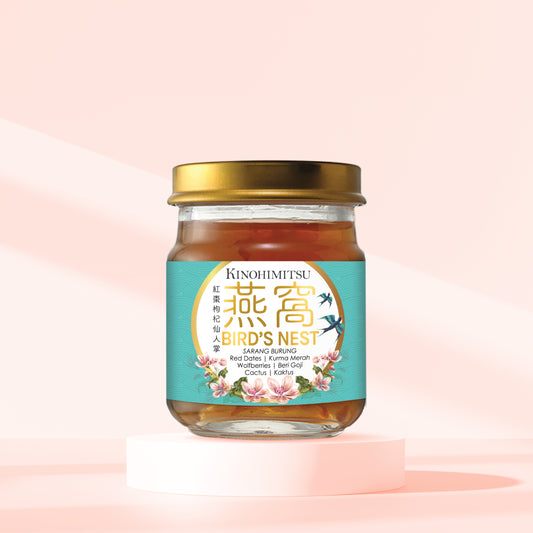 Jar of Kinohimitsu Bird's Nest with Red Dates and Collagen Drink on a light pink background, showcasing a healthy lifestyle supplement. Kinohimitsu Bird's Nest drink with natural ingredients, featuring red dates and collagen in a glass jar with a gold lid, set against a soft pink background for a healthy lifestyle.
