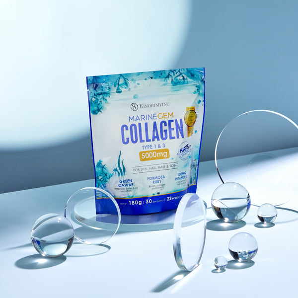 Kinohimitsu Marine Gem Collagen product package with 5000mg label for skin, nail, hair, and joint featuring green caviar, Formosa ruby, and vitamin C. Displayed with glass spheres for an elegant presentation.