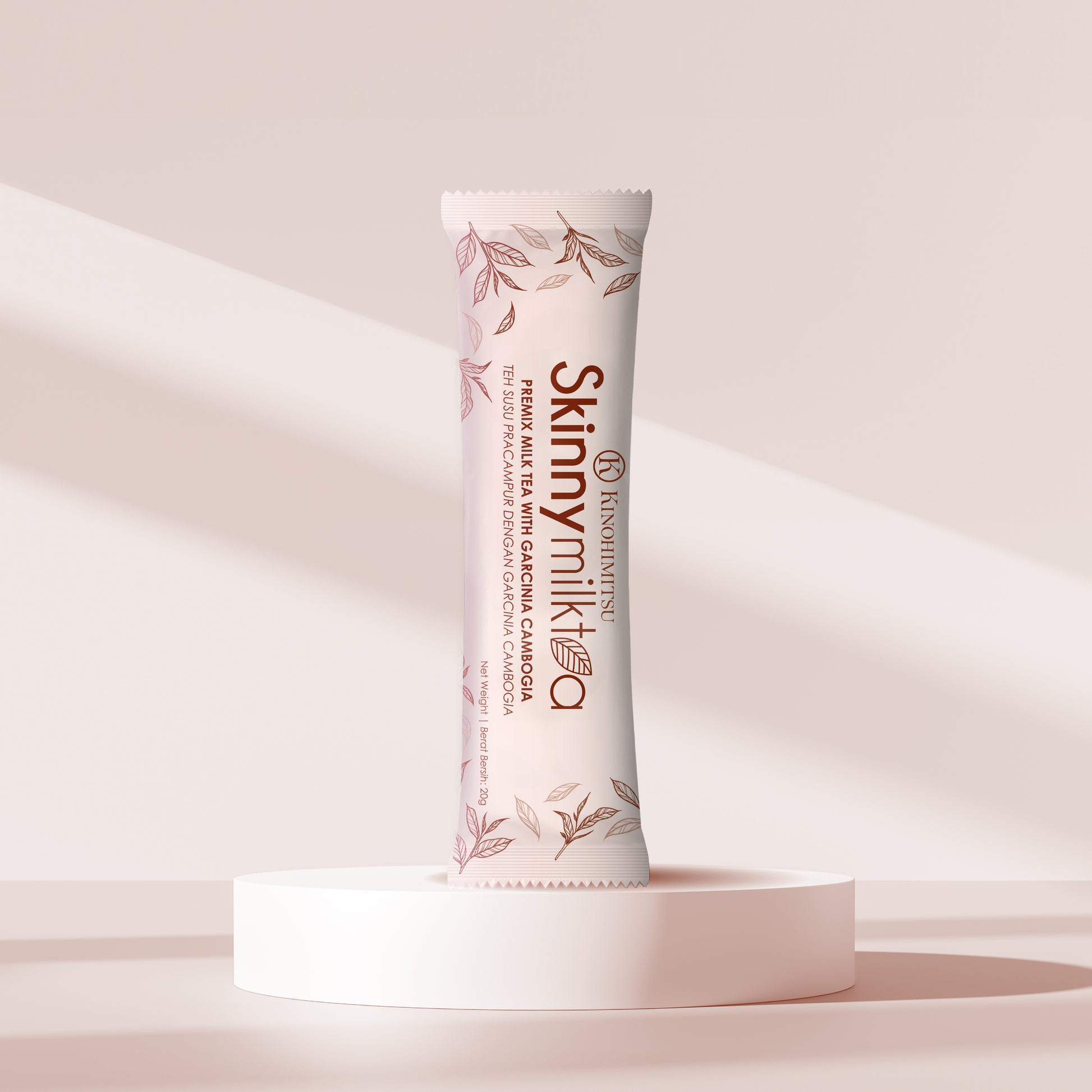 Kinohimitsu Skinny Milk Tea sachet displayed on a minimalist, light-pink background with soft shadows, showcasing the product packaging and highlighting its key ingredient, Garcinia Cambogia, from Kinohimitsu Malaysia.